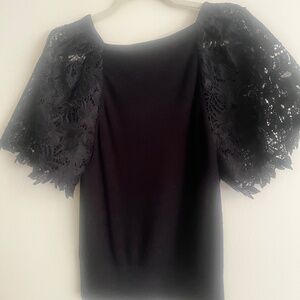 Black knit top with lace sleeves.
